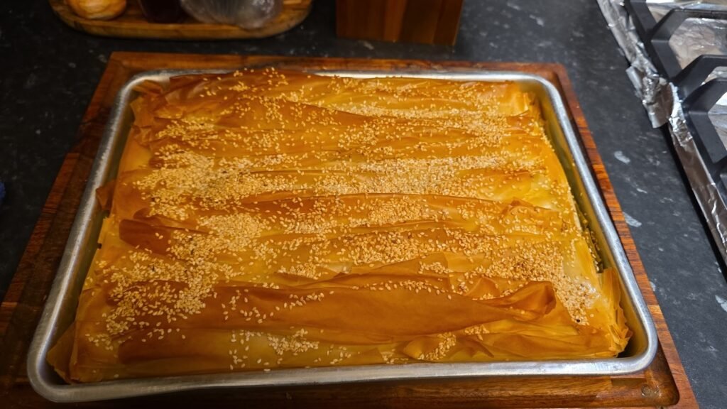 A tray of golden, sesame-topped Greek filo pie at Kalimera, Harpenden